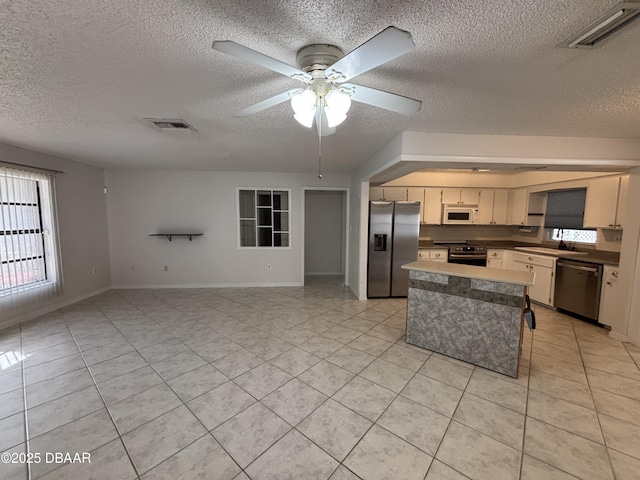 kitchen featuring sink, plenty of natural light, light tile patterned flooring, and appliances with stainless steel finishes