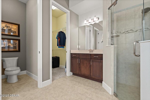 bathroom featuring tile patterned floors, vanity, toilet, and a shower with door