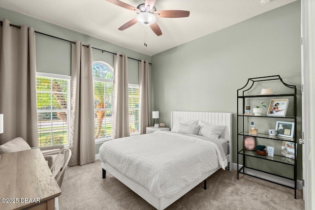 bedroom featuring multiple windows, ceiling fan, and light carpet