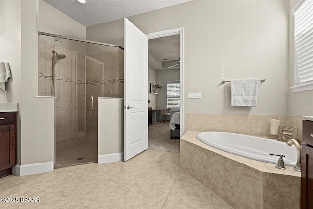 bathroom featuring tile patterned floors, vaulted ceiling, a textured ceiling, vanity, and independent shower and bath