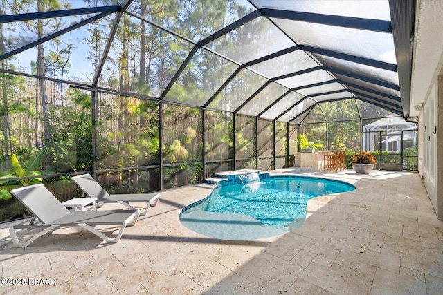 view of swimming pool with pool water feature, a patio area, and a lanai