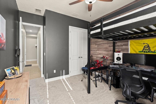 carpeted bedroom with ceiling fan and wooden walls