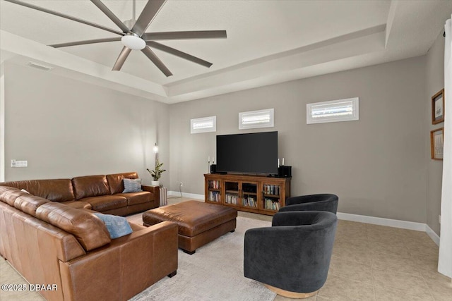 living room featuring a raised ceiling and ceiling fan