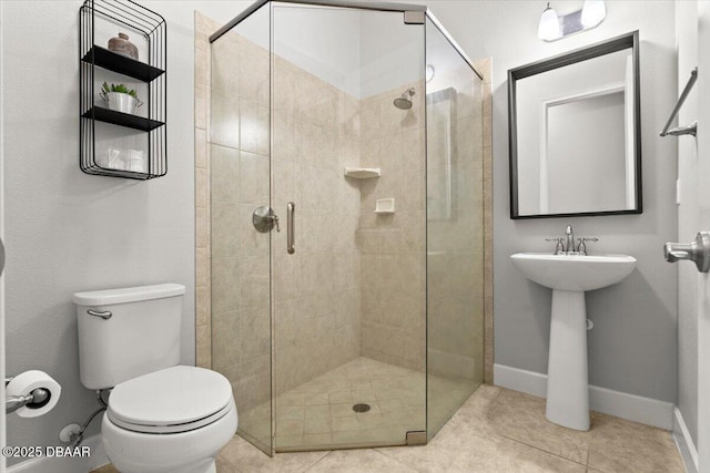 bathroom featuring tile patterned flooring, a shower with shower door, and toilet