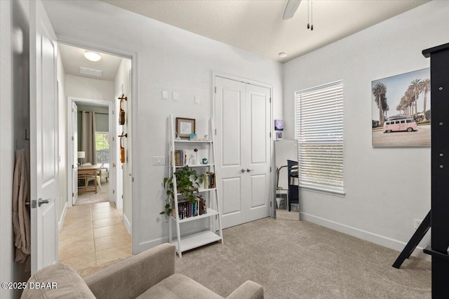 interior space with light carpet and ceiling fan