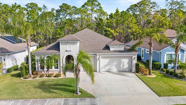 mediterranean / spanish home with a garage and a front lawn