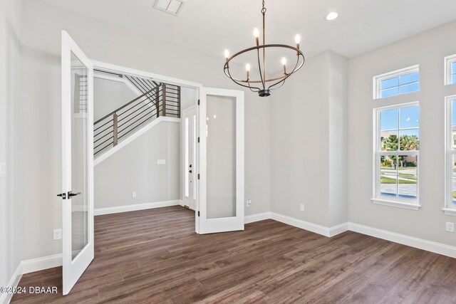 interior space with french doors, dark hardwood / wood-style flooring, and a notable chandelier