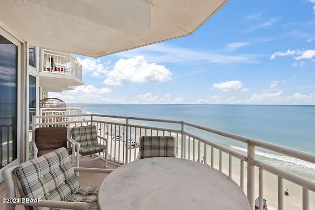 balcony featuring a water view and a view of the beach