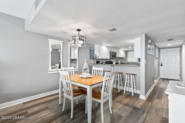 dining room with dark wood-type flooring and a chandelier