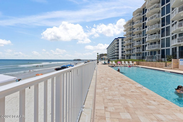 view of pool with a view of the beach and a water view