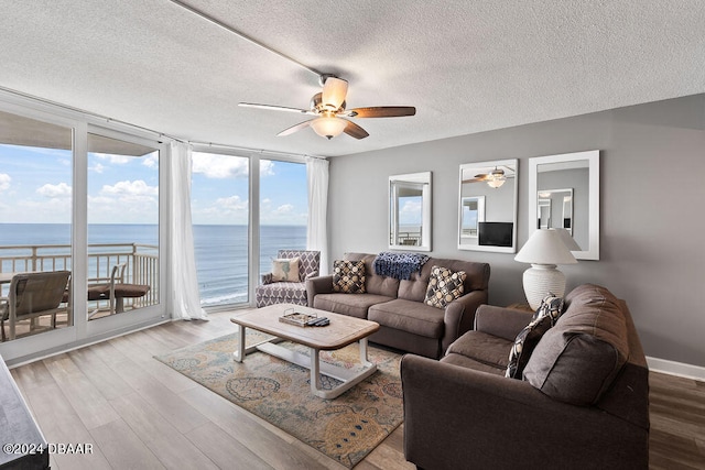 living room with floor to ceiling windows, a textured ceiling, hardwood / wood-style flooring, and ceiling fan