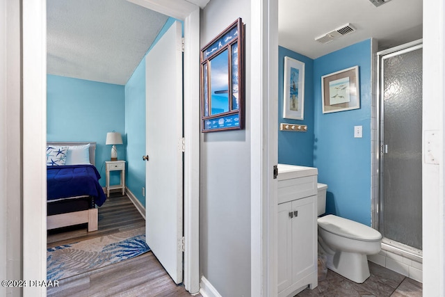 bathroom with vanity, hardwood / wood-style flooring, toilet, and a shower with shower door