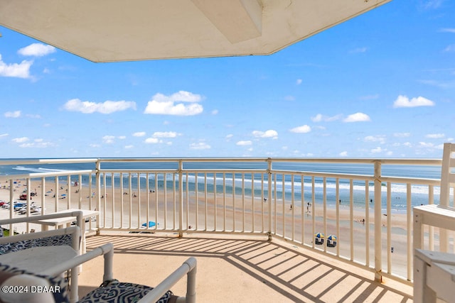 balcony featuring a beach view and a water view