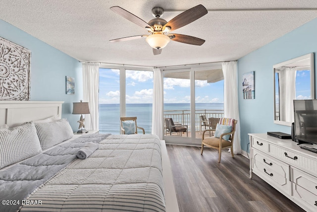 bedroom with access to exterior, multiple windows, and dark hardwood / wood-style flooring