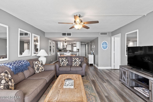 living room featuring a textured ceiling, hardwood / wood-style floors, and ceiling fan with notable chandelier