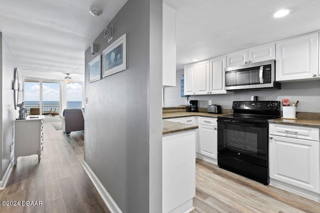 kitchen featuring white cabinets, black range with electric cooktop, and light wood-type flooring