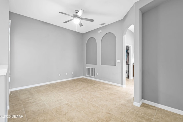 3345 Tesoro Cir, New Smyrna Beach, FL 32168 - spare room with ceiling fan, arched walkways, light tile patterned floors, and baseboards