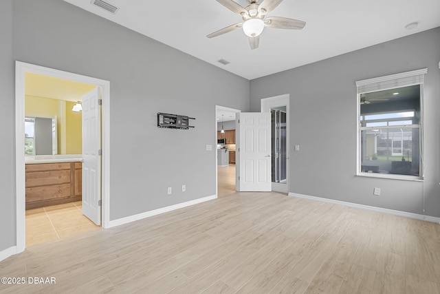 3345 Tesoro Cir, New Smyrna Beach, FL 32168 - unfurnished bedroom with light wood-style flooring, baseboards, ensuite bathroom, and ceiling fan