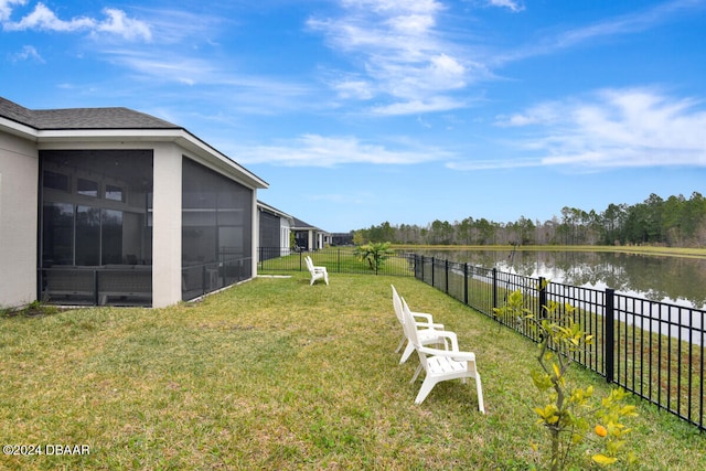 view of yard with a sunroom and a water view