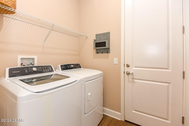 laundry room with independent washer and dryer and dark hardwood / wood-style flooring