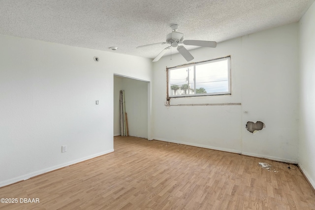 empty room featuring baseboards, ceiling fan, a textured ceiling, and light wood finished floors