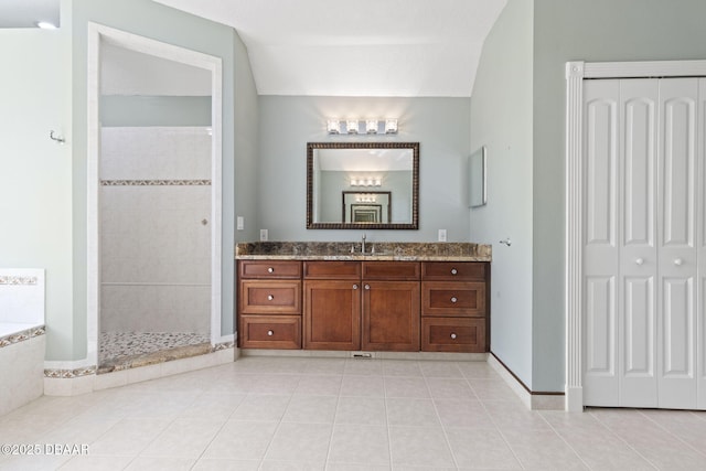 4210 S Peninsula Dr, Port Orange, FL 32127 - bathroom with a closet, vanity, tile patterned flooring, and vaulted ceiling