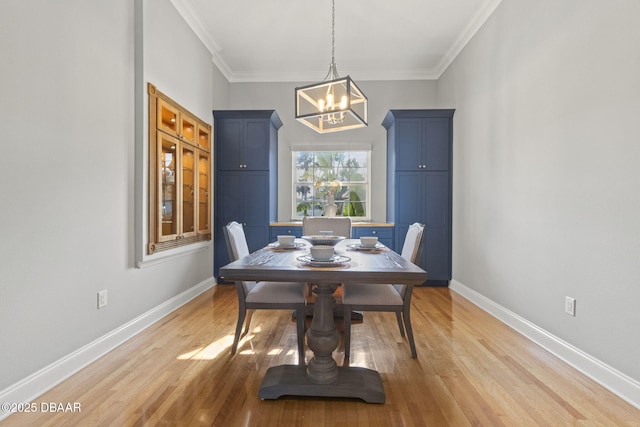 4210 S Peninsula Dr, Port Orange, FL 32127 - dining room featuring a chandelier, light wood-style flooring, baseboards, and crown molding
