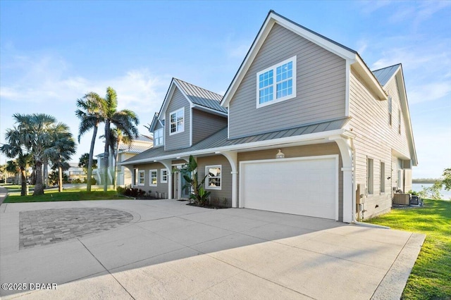 4210 S Peninsula Dr, Port Orange, FL 32127 - view of front facade with driveway, a garage, a standing seam roof, and metal roof