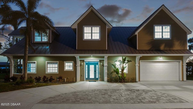 4210 S Peninsula Dr, Port Orange, FL 32127 - view of front of house with driveway, a standing seam roof, metal roof, and a garage