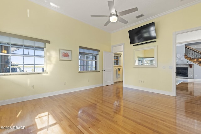 4210 S Peninsula Dr, Port Orange, FL 32127 - spare room featuring a fireplace, ornamental molding, light wood-style floors, and healthy amount of natural light
