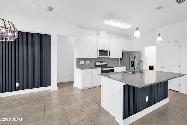 623 Margaritaville Ave, Daytona Beach, FL 32124 - kitchen featuring appliances with stainless steel finishes, white cabinetry, an island with sink, backsplash, and light tile patterned floors