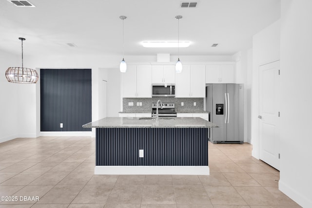 623 Margaritaville Ave, Daytona Beach, FL 32124 - kitchen with appliances with stainless steel finishes, decorative backsplash, a kitchen island with sink, white cabinets, and light stone counters