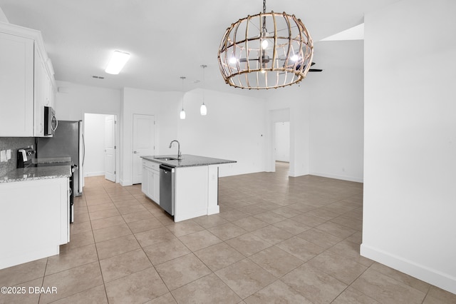 623 Margaritaville Ave, Daytona Beach, FL 32124 - kitchen with appliances with stainless steel finishes, light tile patterned flooring, a chandelier, white cabinets, and a kitchen island with sink