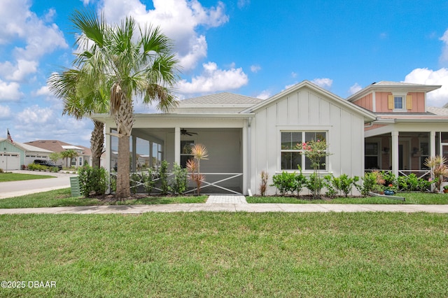623 Margaritaville Ave, Daytona Beach, FL 32124 - view of front of property featuring ceiling fan, board and batten siding, a front yard, and a sunroom
