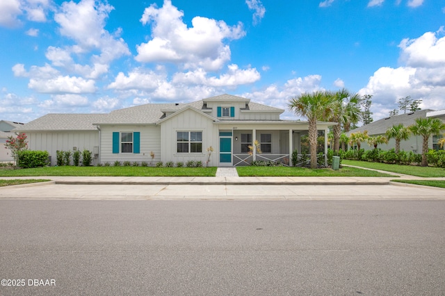 623 Margaritaville Ave, Daytona Beach, FL 32124 - view of front of house with board and batten siding, a porch, and a front yard
