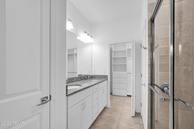 623 Margaritaville Ave, Daytona Beach, FL 32124 - full bathroom featuring a spacious closet, double vanity, a shower stall, and tile patterned floors