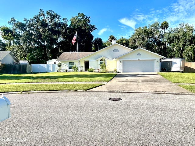 single story home featuring a garage and a front yard