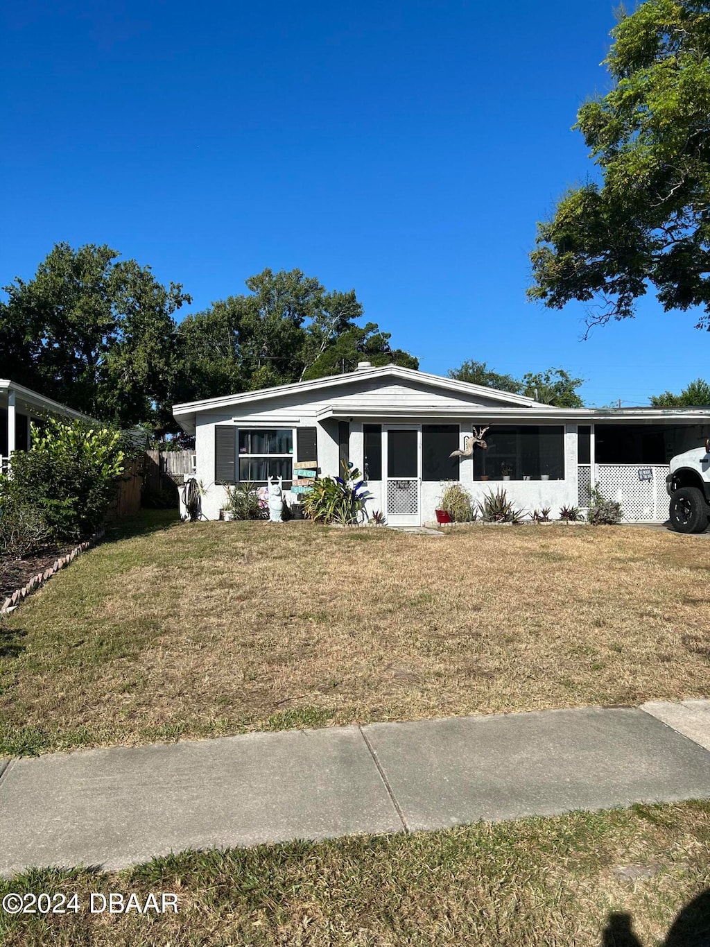 view of front of home with a carport and a front lawn