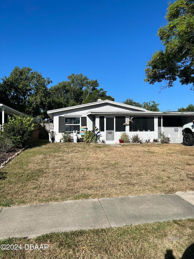 view of front of home with a carport and a front lawn