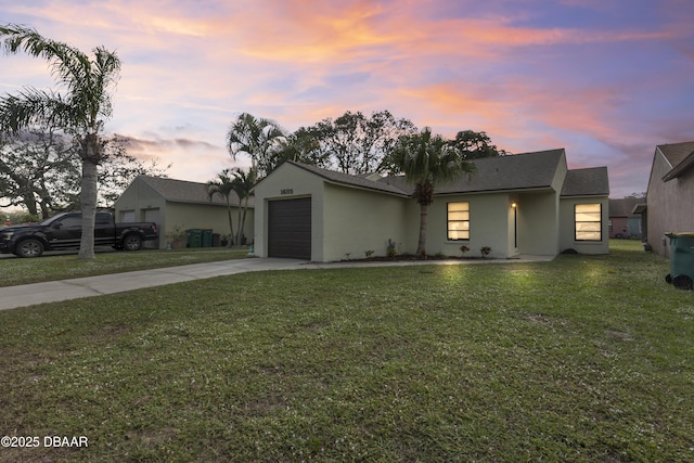 view of front of property with a garage and a yard