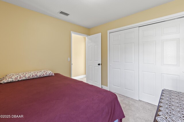 bedroom featuring light carpet and a closet