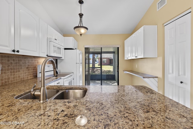 kitchen with lofted ceiling, backsplash, sink, hanging light fixtures, and white cabinetry