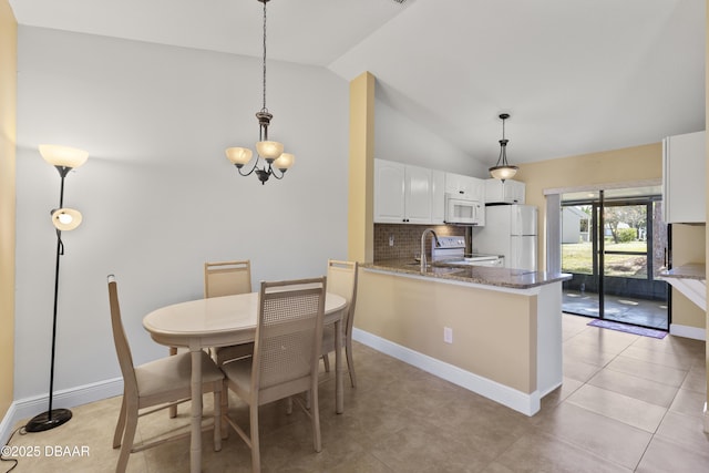 tiled dining room featuring a chandelier and lofted ceiling