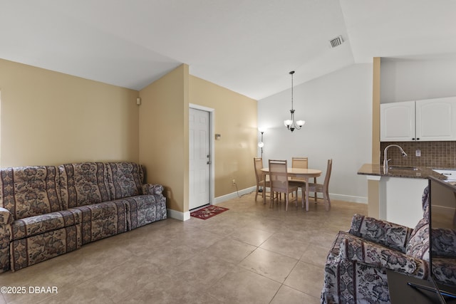 living room with an inviting chandelier, light tile patterned floors, sink, and vaulted ceiling