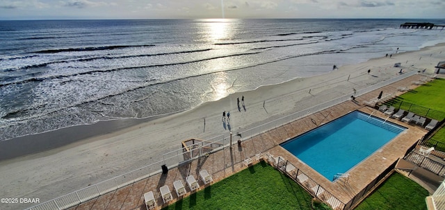 exterior space with a beach view, fence, and a water view