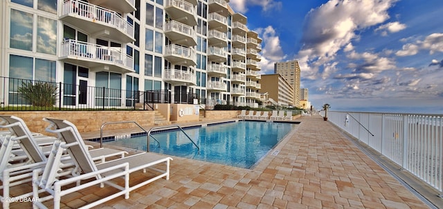 community pool featuring fence and a patio