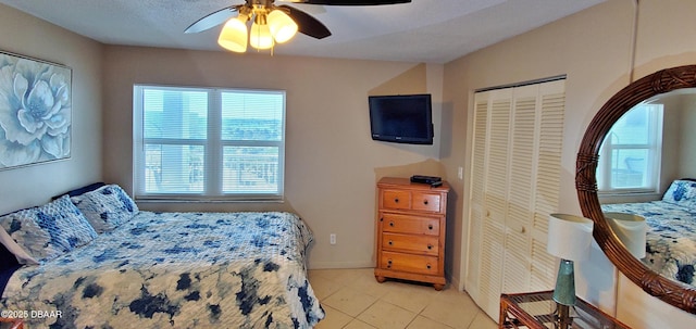 bedroom with tile patterned floors, a closet, and ceiling fan