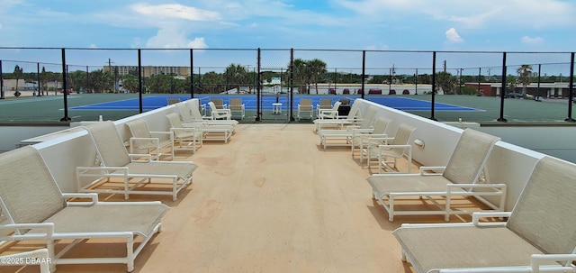 exterior space featuring a tennis court and fence