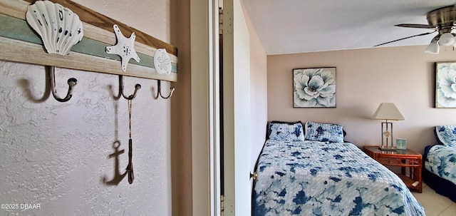 bedroom featuring ceiling fan and a textured wall