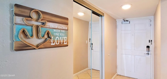 corridor featuring light tile patterned floors and baseboards